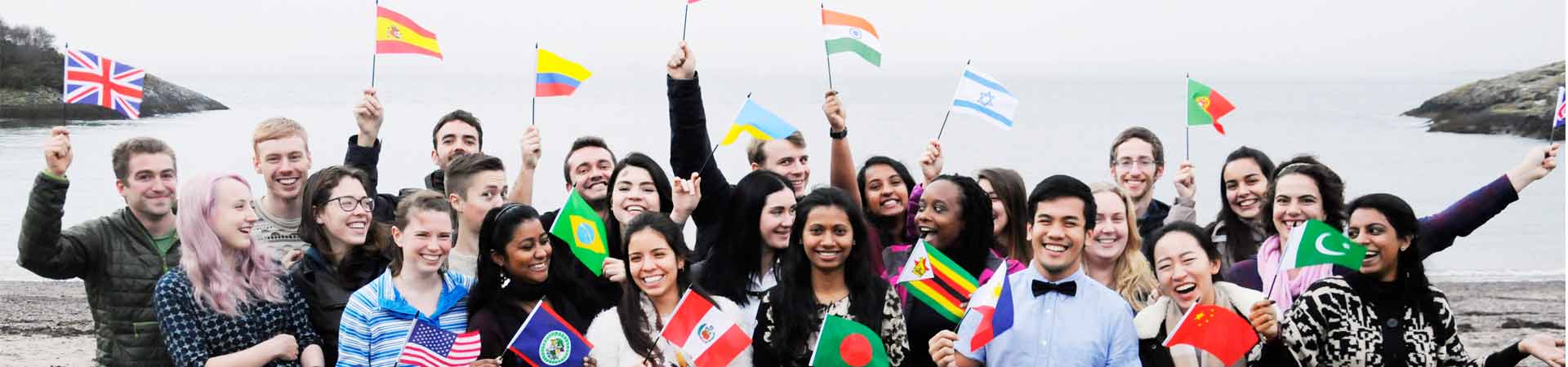A group of international students waving flags showing their nationalities.